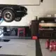 Extincteurs rouges installés dans un garage automobile équipé d'un pont élévateur