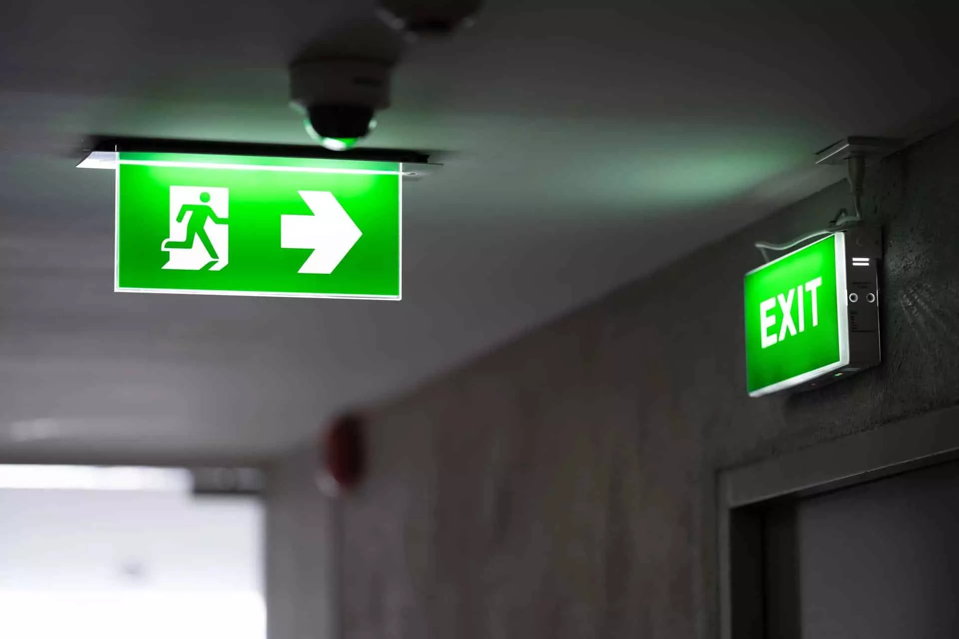 Panneaux lumineux verts d'éclairage de secours indiquant la sortie de secours dans un couloir