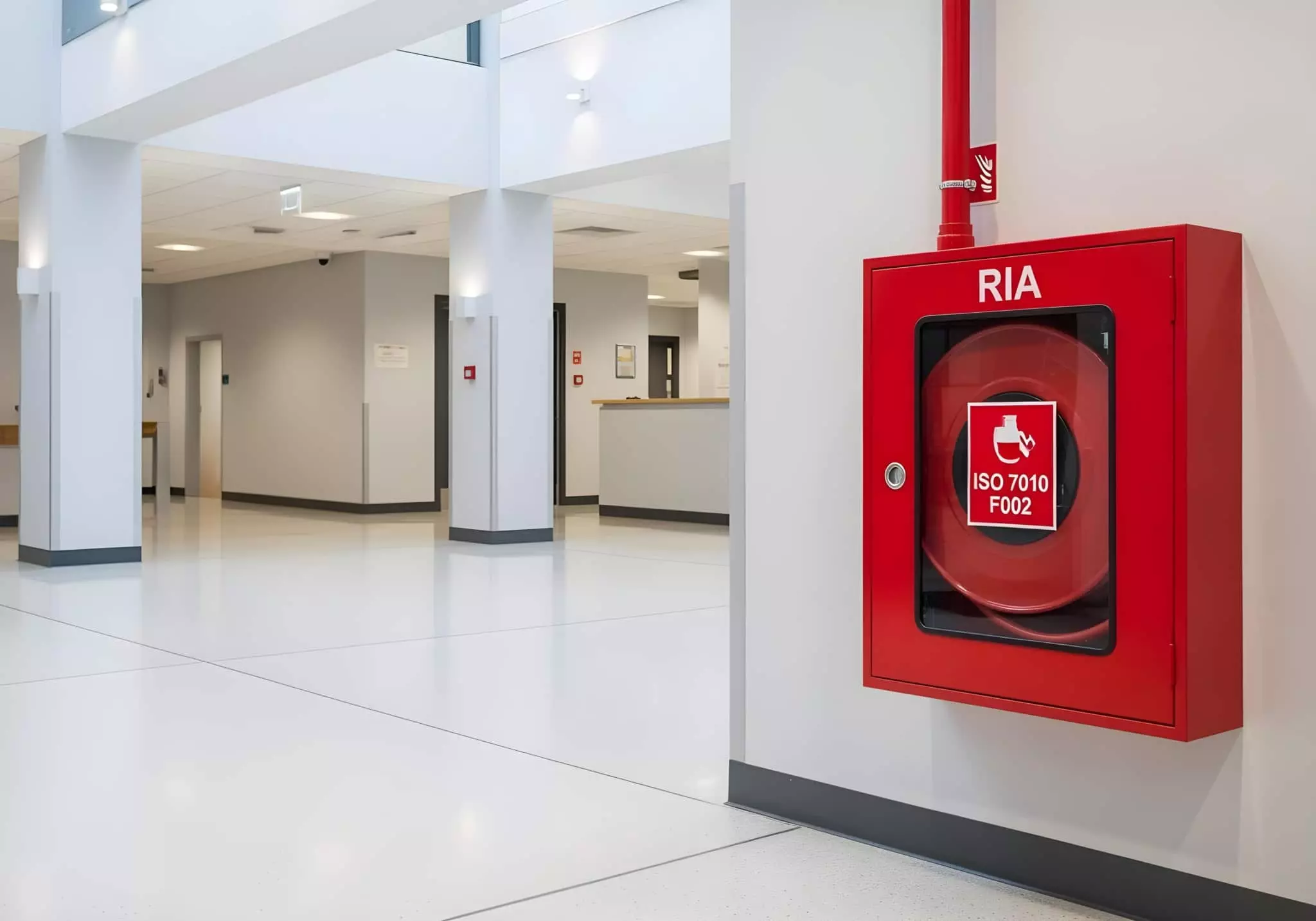 Coffret rouge Robinet d'Incendie Armé RIA fixé au mur dans un hall d'accueil