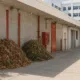 Tas de déchets verts près d'une porte coupe-feu rouge en milieu hospitalier