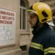 Pompier consultant le plan d'évacuation près du panneau commission de sécurité incendie de la mairie