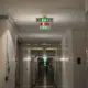 Couloir de bureau avec panneaux de signalisation incendie lumineux indiquant les issues de secours