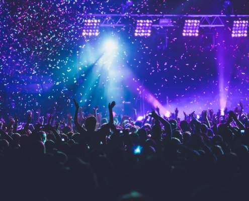 Foule en concert avec confettis et jeux de lumières, enjeu de sécurité incendie en salle ERP