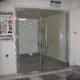 Porte coupe-feu vitree grillagee avec signalisation d'issue de secours dans un couloir