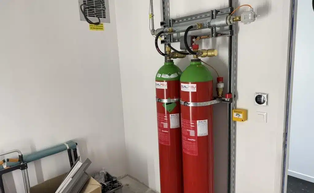 Extinction automatique par Qualifeu Bouteilles rouges d'extinction automatique IG55 Qualifeu installées sur rack métallique mural