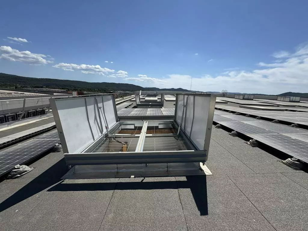 désenfumage Qualifeu Exutoire de désenfumage ouvert sur toiture équipée de panneaux photovoltaïques, installation Qualifeu